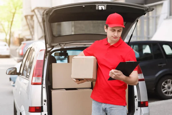 Compras en línea y entrega. Mensajero con tableta y caja va a casa del cliente — Foto de Stock