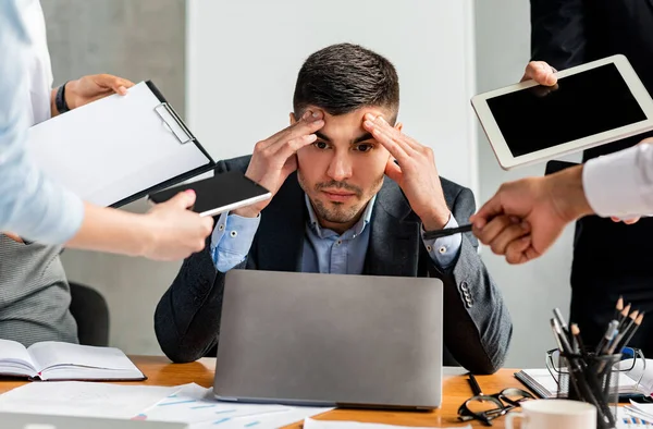 Gestresste zakenman moe van de taken die op het werk in kantoor zitten — Stockfoto