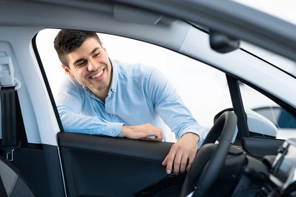 Hombre feliz eligiendo nuevo auto en la tienda de concesionarios —  Fotos de Stock