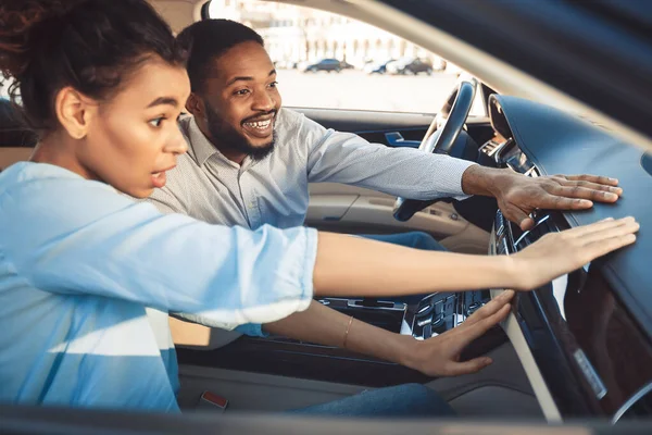 Emocionada pareja afroamericana tocando el auto de verificación en el concesionario —  Fotos de Stock