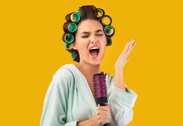 Hausfrau kräuselt Haare, singt Pinsel wie Mikrofon im Studio — Stockfoto