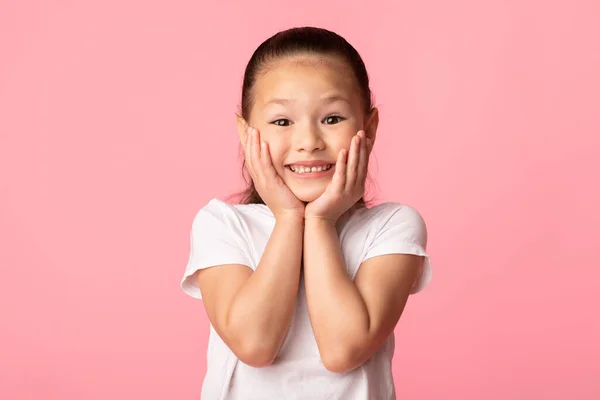 Asiatisk flicka rörande kinder känsla upphetsad på studio — Stockfoto