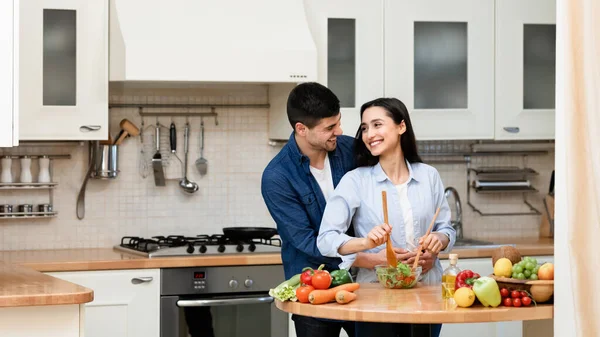 Preciosa pareja preparando la cena cortando verduras en su casa —  Fotos de Stock