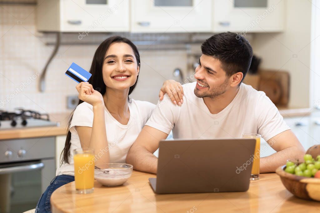 Happy couple holding debit card for shopping online