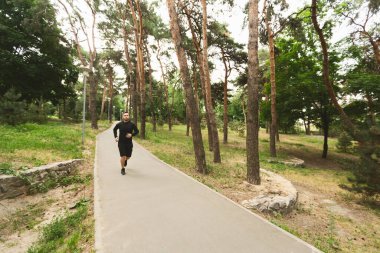 Koşucu yolda koşuyor, dışarıda egzersiz yapıyor.