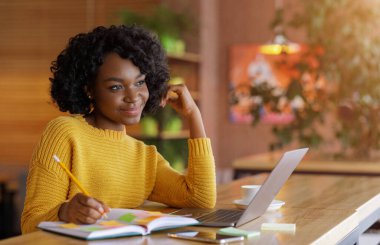 Yaratıcı serbest çalışan kız yeni bir proje düşünüyor, kafede çalışıyor.