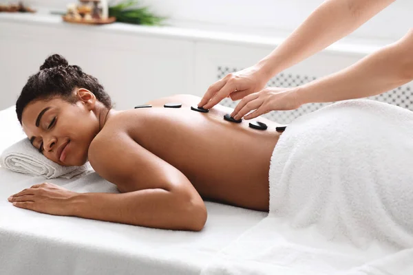 Healthy hot stone massage for tranquil black woman — Stock Photo, Image