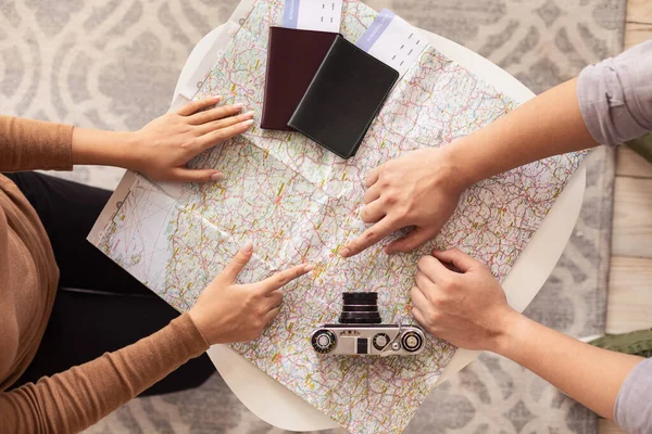 使用旅行地图的夫妇在家中选择目的地，俯瞰 — 图库照片