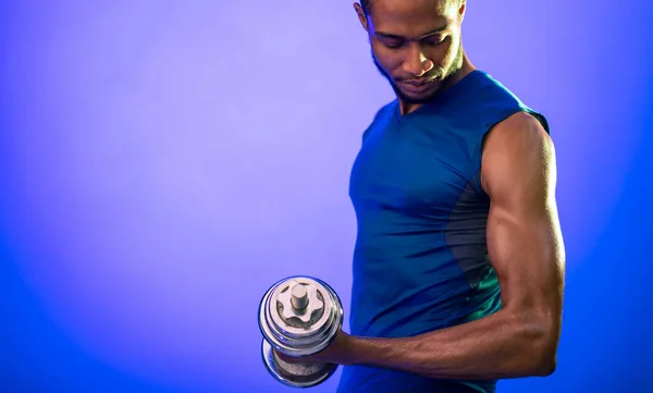 Muscolare nero uomo esercizio con manubri durante l'allenamento in studio — Foto Stock