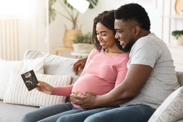 Wesoła para małżeńska patrząc na ultradźwiękowy obraz swojego dziecka — Zdjęcie stockowe