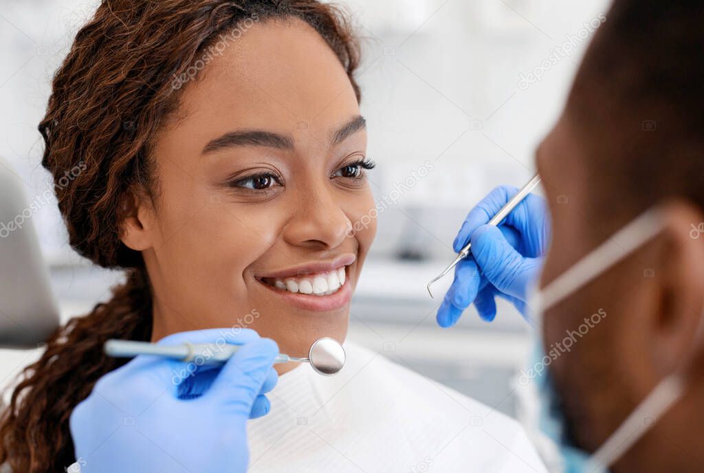 Close up of black girl smiling to male dentist