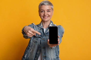 Olumlu Olgun Kadın Siyah Boş Ekran ile Akıllı Telefonu Sunar, Aygıtı Göstererek