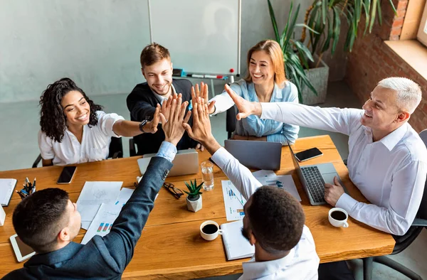 Business Team ger high-five sitter vid bordet i moderna kontor — Stockfoto