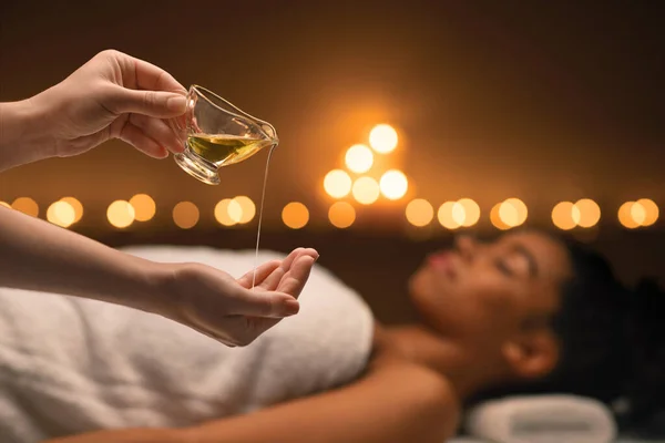 Thérapeute appliquer de l'huile de massage sur les mains avant la thérapie au spa — Photo