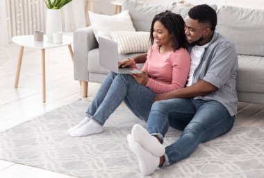 Birlikte tatil planlıyoruz. İnternette dizüstü bilgisayarı olan mutlu siyah çift.