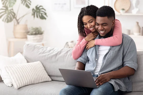 Heureux couple afro-américain naviguant sur Internet sur ordinateur portable à la maison — Photo