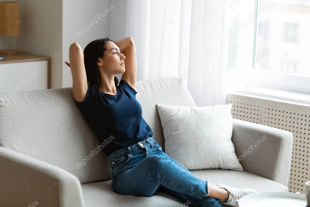 Relaxed Woman Sitting On Sofa Relaxing On Weekend Indoor