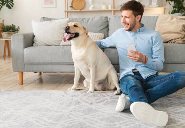Cep telefonu kullanan köpekli bir gencin portresi