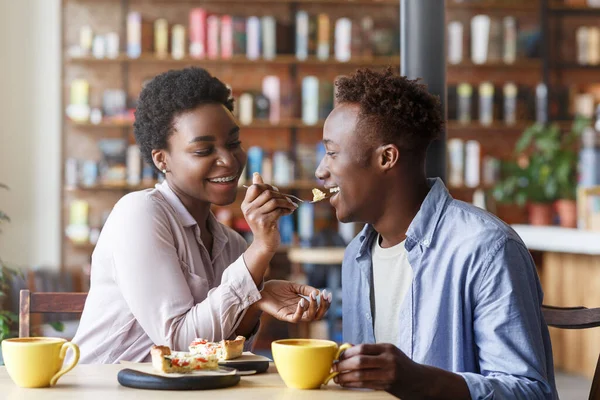 Belle fille noire nourrissant tarte délicieuse à son petit ami au café confortable — Photo