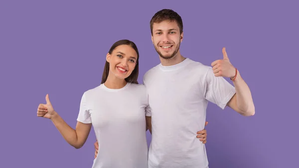 Felice coppia mostrando pollici in su e sorridente — Foto Stock