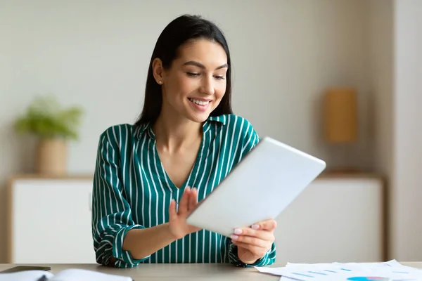 Vrouw met behulp van tablet op het werk surfen op internet zitten in Office — Stockfoto