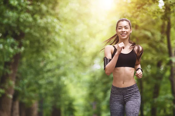 Mode de vie sain. sportif asiatique fille dans jogging dans ville parc — Photo