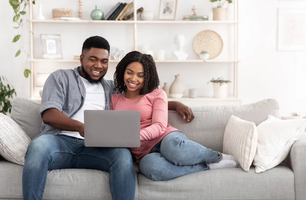 Hafta sonu eğlencesi. Evli Afro Çift Evde Dizüstü bilgisayar kullanıyor, Film seyrediyor. — Stok fotoğraf
