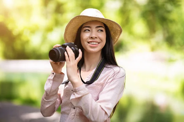 Hobbies exteriores. Feliz mulher asiática viajante tirar foto com câmera moderna — Fotografia de Stock