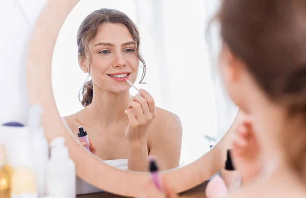 Schöne Dame trägt Lippenstift vor dem Spiegel auf — Stockfoto