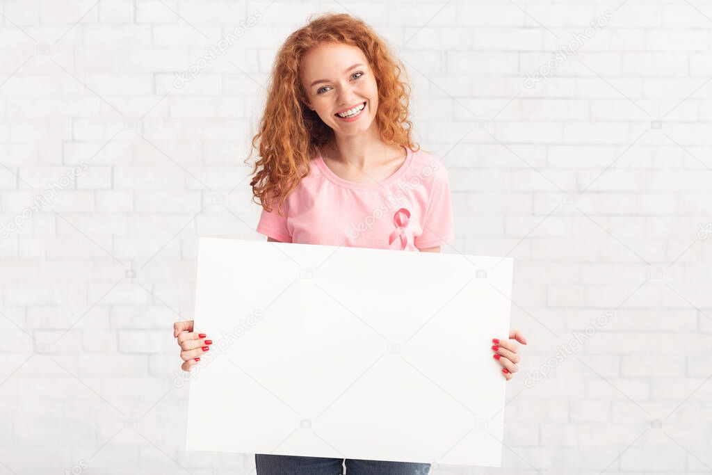 Woman Holding Poster Wearing Breast Cancer T-Shirt Over White Wall