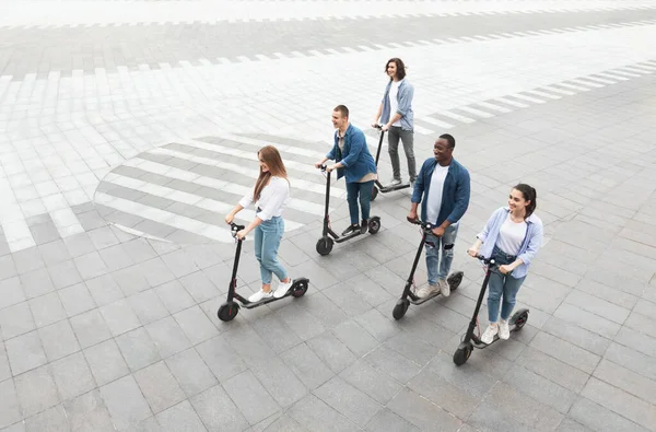 Amigos teniendo agradable paseo en scooters de patada eléctrica — Foto de Stock