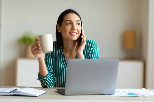 Business Woman rozmawia przez telefon komórkowy siedzi na laptopie w biurze — Zdjęcie stockowe