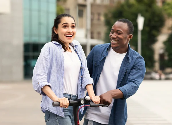 Guy e menina ter passeio agradável em scooter de chute elétrico — Fotografia de Stock