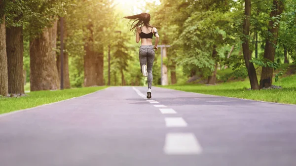 Morgens joggen. Unerkennbares Mädchen läuft im leeren Park, Rückansicht — Stockfoto