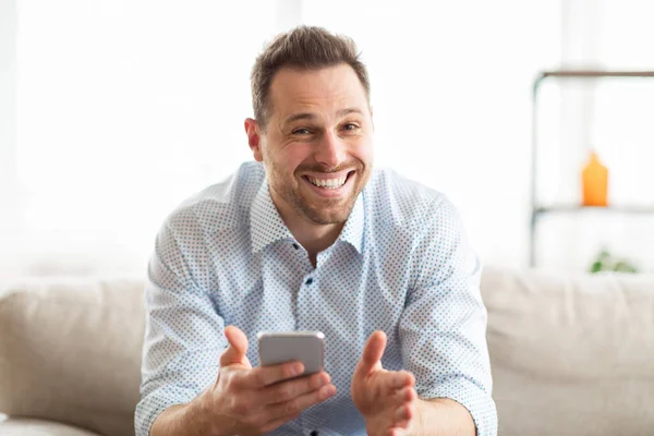 Excited adult man feeling ecstatic holding cell phone — Stock Photo, Image