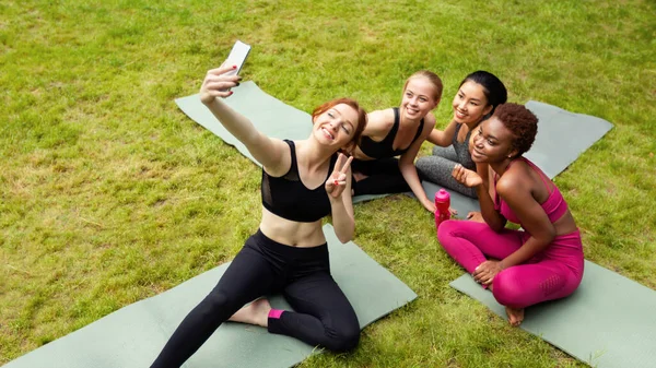 Happy diversas meninas tomando selfie após aula de ioga ao ar livre, espaço de cópia — Fotografia de Stock