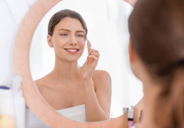 Güzel genç bayan sabah güzelliği rutinini yapıyor.