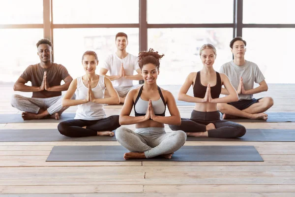 Stile di vita sano. Giovani in classe internazionale di yoga facendo esercizi asana — Foto Stock