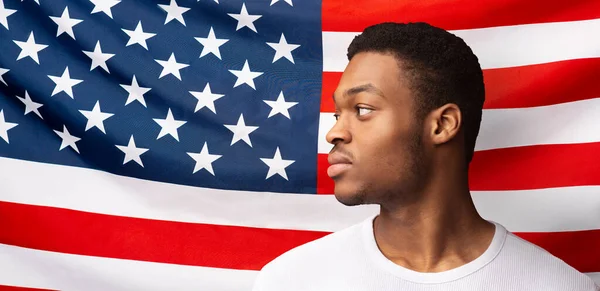 黒が重要。アメリカ国旗の背景に立つ若いアフリカ人の男、パノラマ — ストック写真
