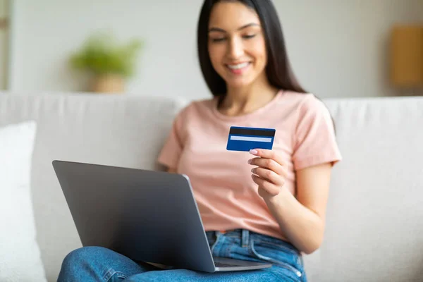 Kredi kartı kullanan kadın laptopunu içeride koltukta oturuyor. — Stok fotoğraf