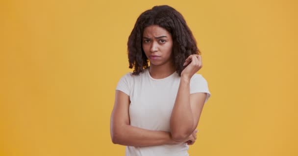 Sceptische zwarte vrouw krullen haar haar en schudden hoofd nee — Stockvideo