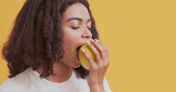 신선 한 사과를 먹고 즐기는 아프리카 계 미국인 여자 — 비디오