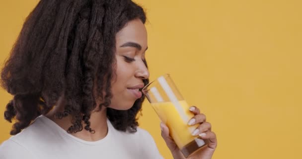 Feliz chica afroamericana bebiendo jugo de naranja fresco — Vídeos de Stock