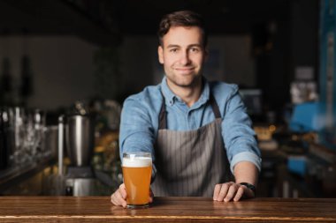 Pub 'da kutlarız. Yakışıklı müşteri için köpüklü bir bardak light bira veriyor.