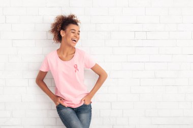 Beyaz Duvarın Üzerinde Kurdele Sembollü Pembe Tişört Giyen Kadın