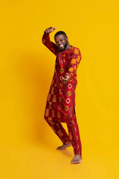 Engraçado bonito cara em vestido africano posando sobre amarelo — Fotografia de Stock