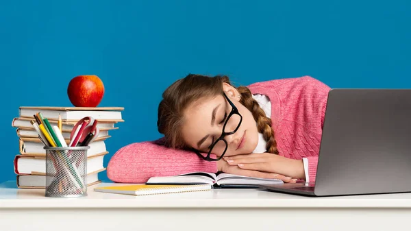 Adolescente stanco. Ragazza pupilla in occhiali dorme a tavola con computer portatile, penne, libri e mela — Foto Stock