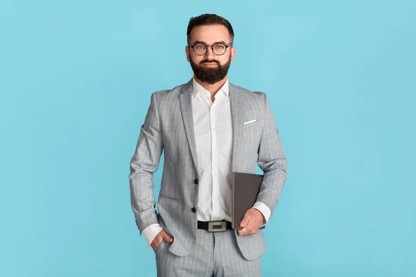 Confident business owner in formalwear and glasses holding tablet computer on blue background — Stock Photo, Image