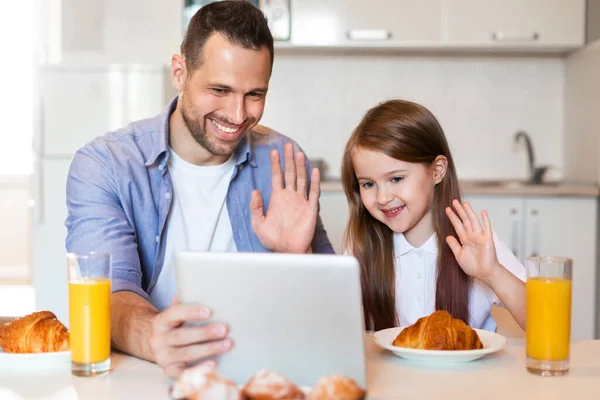 Pai e filha fazendo videochamada tomando café da manhã em casa — Fotografia de Stock