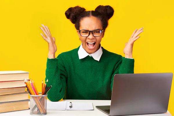 Nervous afro teen shouting sitting at desk — ストック写真